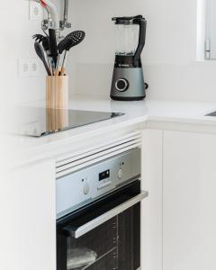 a kitchen with a black and white appliance at Salicórnia in Olhão