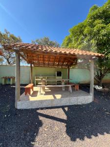a wooden pavilion with a bench and a table at Quintal De Minas in Delfinópolis