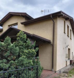 a house with a fence in front of it at Nocleg pod Orzechem Apartament z 2 pokojami in Wapnica