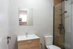 a bathroom with a sink and a toilet and a mirror at Apartamento con terraza en la playa in Cala del Moral