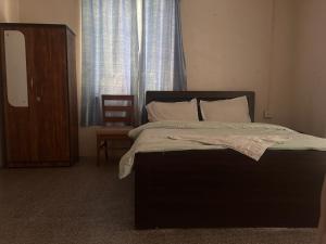a bed in a bedroom with a chair and a window at Paddington coffee house in Nāmthāng