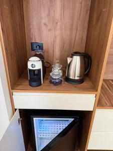 Una encimera de cocina con una cafetera y una tostadora. en Army Apartment, en Durrës