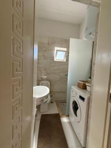 Un baño con lavadora y lavabo. en Army Apartment, en Durrës
