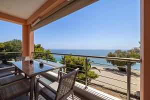 a balcony with a table and chairs and the ocean at Vista al Mar in Zakynthos Town