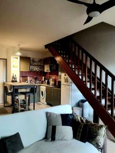 Una sala de estar con un sofá blanco y una cocina. en K a Z - L'Ara Bleu, en Saint-Denis