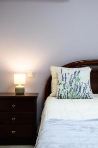 a bed with a pillow and a nightstand with a lamp at Casa do Pescador - Vila Nova de Cerveira in Vila Nova de Cerveira