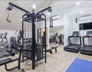 a gym with treadmills and machines in a room at The Palmirah Surin by SP in Surin Beach
