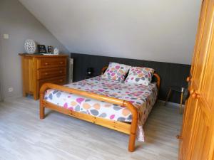 una camera da letto con un letto in legno con una cassettiera e un letto sidx sidx sidx di Le Grand Chêne a Magnac-Bourg