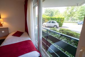 Postel nebo postele na pokoji v ubytování Logis Hotel Arc En Ciel