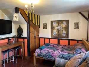 a bedroom with a bed and a desk and a television at Yarm Cottages The Byre Sleeping 4 Next to Fox Covert Pub in Kirk Leavington