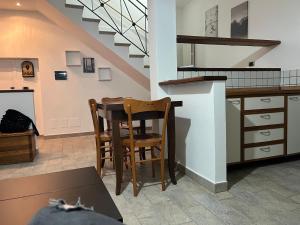 a kitchen with a table and chairs and a staircase at La Lucanella in centro a Rotonda in Rotonda