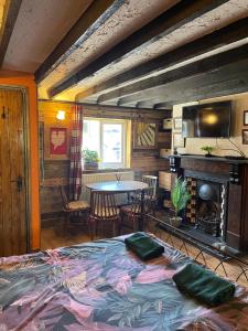Pokój z łóżkiem, stołem i kominkiem w obiekcie Yarm Cottages The Byre Sleeping 4 w mieście Kirk Leavington