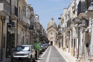 una strada con auto parcheggiate e un edificio di Historic Town Center, Parking Nearby a Villa Castelli