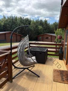 a hammock and a grill on a deck at Chloe Cabin in West Thirston