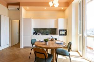 une cuisine et une salle à manger avec une table et des chaises en bois dans l'établissement Appartamento Martini Stazione Centrale, à Milan
