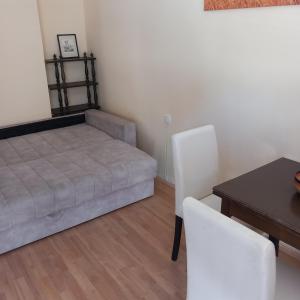 a bedroom with a bed and a table and chairs at Apartman M 4 in Novi Sad