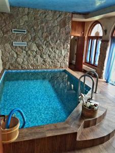 a pool in a house with a stone wall at Rent in summer in Ragaciems
