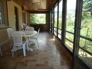 a dining room with a table and chairs and windows at le tilleul in Millau