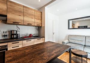 a kitchen with a wooden table and a couch at L'Apparté Confort in Thonon-les-Bains