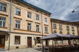 利沃夫利沃夫中心公寓的前面有桌子和伞的建筑