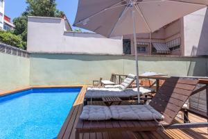 a patio with an umbrella and chairs next to a pool at Apartment Barcelona Rentals - Gracia Pool Apartments Center in Barcelona