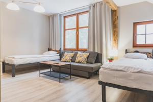 Una sala de estar con dos camas y un sofá en Willa Cross, en Szklarska Poręba
