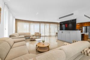 ein Wohnzimmer mit Sofas und Fernseher in der Unterkunft Shani house of style katalina villa in Eilat