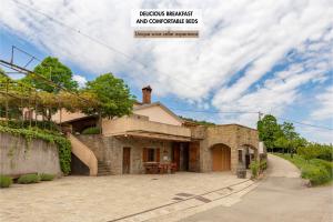 una casa in pietra con un tavolo in un vialetto di Ražman Wine Rooms a Gračišče
