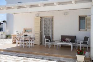 een patio met witte meubels en een tafel en stoelen bij Pietra di Luna relaxing private terrace in Polignano a Mare
