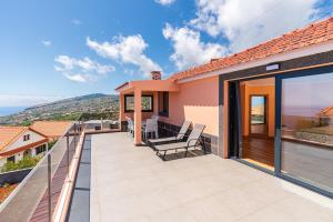 ein Haus mit Balkon und Aussicht in der Unterkunft Casa Por Do Sol ll in Arco da Calheta