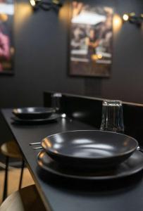 a black table with two black plates on it at Appartement centre ville Laval avec cinéma in Laval +8 photos