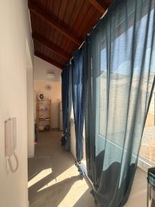 a hallway with a window with blue curtains at Camilla Lipari House - Canneto in Lipari