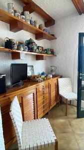 a living room with a television and two chairs at Villa La Birbirella in Conca dei Marini +53 photos