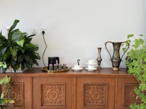 a wooden cabinet with two vases and cups on it at Apartament Jezioro Łabędzie in Białla