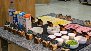 a table with cheese and other food on a counter at Hotel Greenville by Slim Hotéis in Primavera do Leste +58 photos