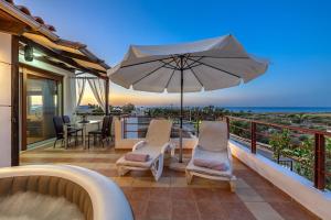 Un balcón con una mesa y sillas y una sombrilla. en Chris Sea View Apt with Hot Tub, en Gouves