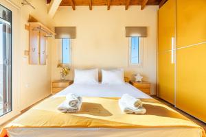 Un dormitorio con una cama grande con toallas. en Chris Sea View Apt with Hot Tub, en Gouves