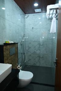 a bathroom with a shower and a toilet and a sink at Aanvi Suites RR nagar in Bengaluru
