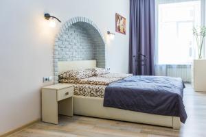 a bedroom with a bed and a brick wall at Apartamenty u centri Lvova - Lviv in Lviv