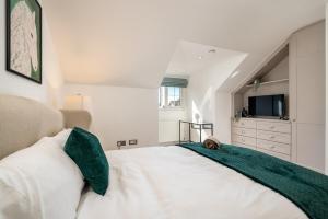 a bedroom with a large white bed with a television at The Maple Nest - Sleep 9-Free WiFi - Modern Bedrooms in Sands