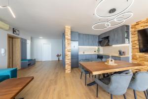 a kitchen and dining room with a wooden table and chairs at Luxury Apartments Calithea-Balchik, Free Parking in Balchik +110 photos