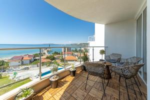 a balcony with a table and chairs and a view of the ocean at Luxury Apartments Calithea-Balchik, Free Parking in Balchik