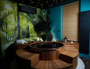 a jacuzzi tub in a room with a jungle at La suite Emois et Toi in Orléans