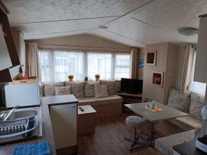 克诺克-海斯特Rebeka's Caravan的客厅里有一张沙发和一张桌子。