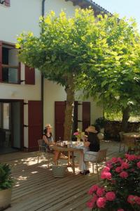 two women sitting at a table under a tree at Venta de Arrieta in Saragüeta