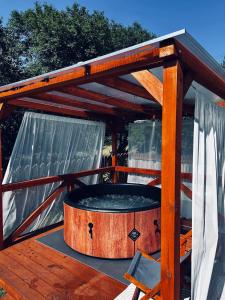 drewniana pergola z wanną z hydromasażem na tarasie w obiekcie Domek na skraju lasu w Uniejowie