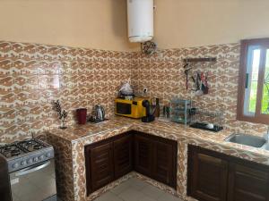 a kitchen with a counter top with a microwave at Maison tranquille in Saly Portudal