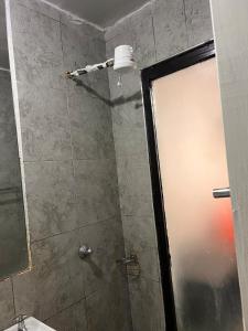 a shower with a glass door in a bathroom at The cozy Cove in Nairobi