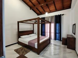 a bedroom with a canopy bed in a room at Villa Dew Drops - Galle in Pedinnoruwa