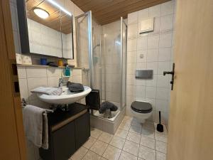 a bathroom with a sink and a shower and a toilet at Landhaus Brigitte in Obermaiselstein +64 photos